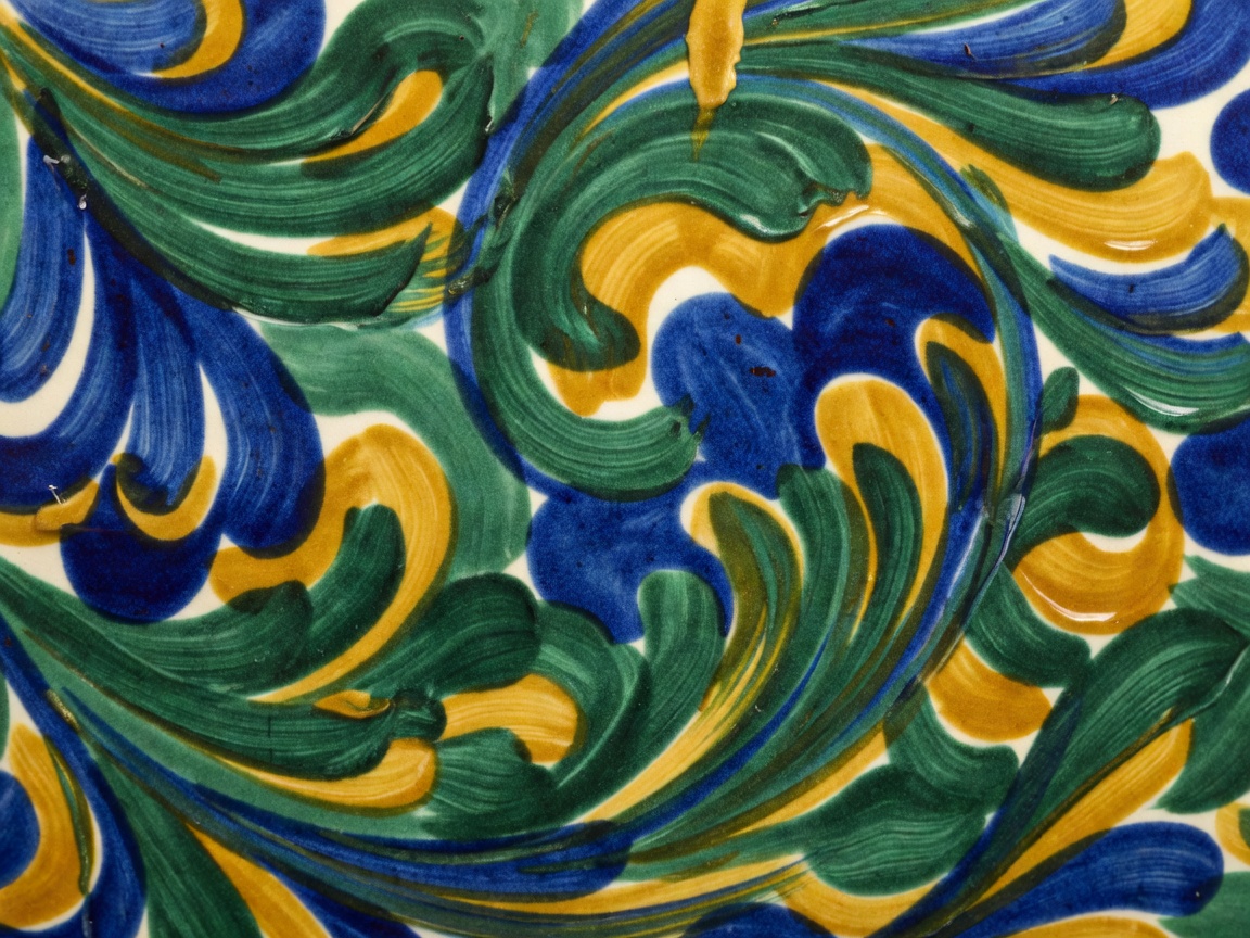 Macro detail of hand-painted Deruta majolica ceramic glaze brushstrokes showing subtle mineral pigment variance